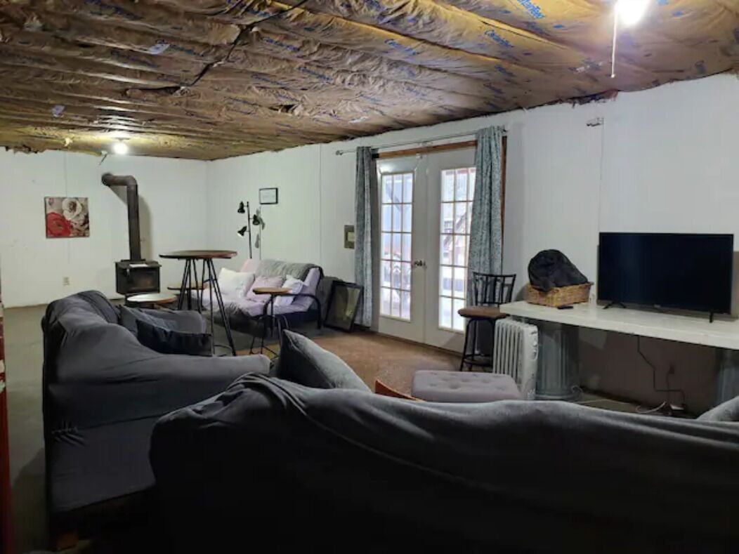 Ein Wohnzimmer mit einer Couch, einem Tisch, einem Fernseher und einem Kamin.