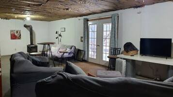 Ein Wohnzimmer mit einer Couch, einem Tisch, einem Fernseher und einem Kamin.