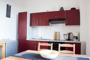 Microondas, cafetera o tetera, utensilios de cocina y mesa de comedor