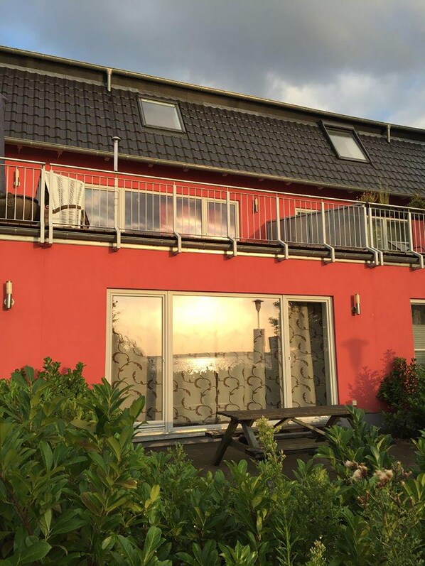 A red building with a balcony and a large window. - Beach house,200 sq meters. Wf., Directly on the Plauer See, Müritz, 30m to beach (Fünfseen Lenz Süd)