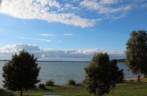 A lakeside view with trees, a bench, and a picnic table. - Beach house,200 sq meters. Wf., Directly on the Plauer See, Müritz, 30m to beach (Fünfseen Lenz Süd)