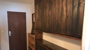 A hallway with a wooden door, a wooden cabinet, and a shelf unit. - Studio with mountain and lake view, Tignes (Tignes)