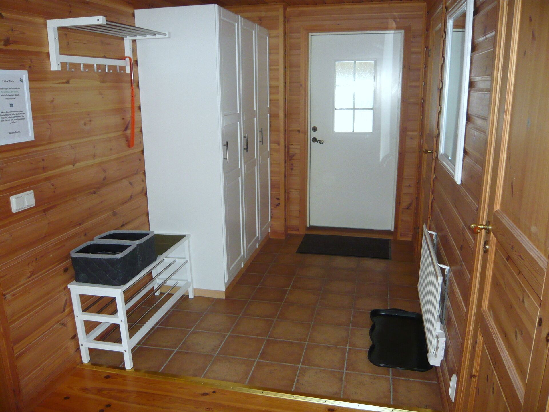 A compact kitchen with white cabinets, a small countertop, and a black trash bin.