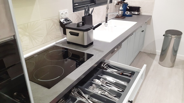 A modern kitchen with an induction cooktop, a built-in oven, a coffee maker, and a stainless steel trash can. - Family villa with heated pool, in a quiet location close to the lake and center. (Gujan-Mestras)