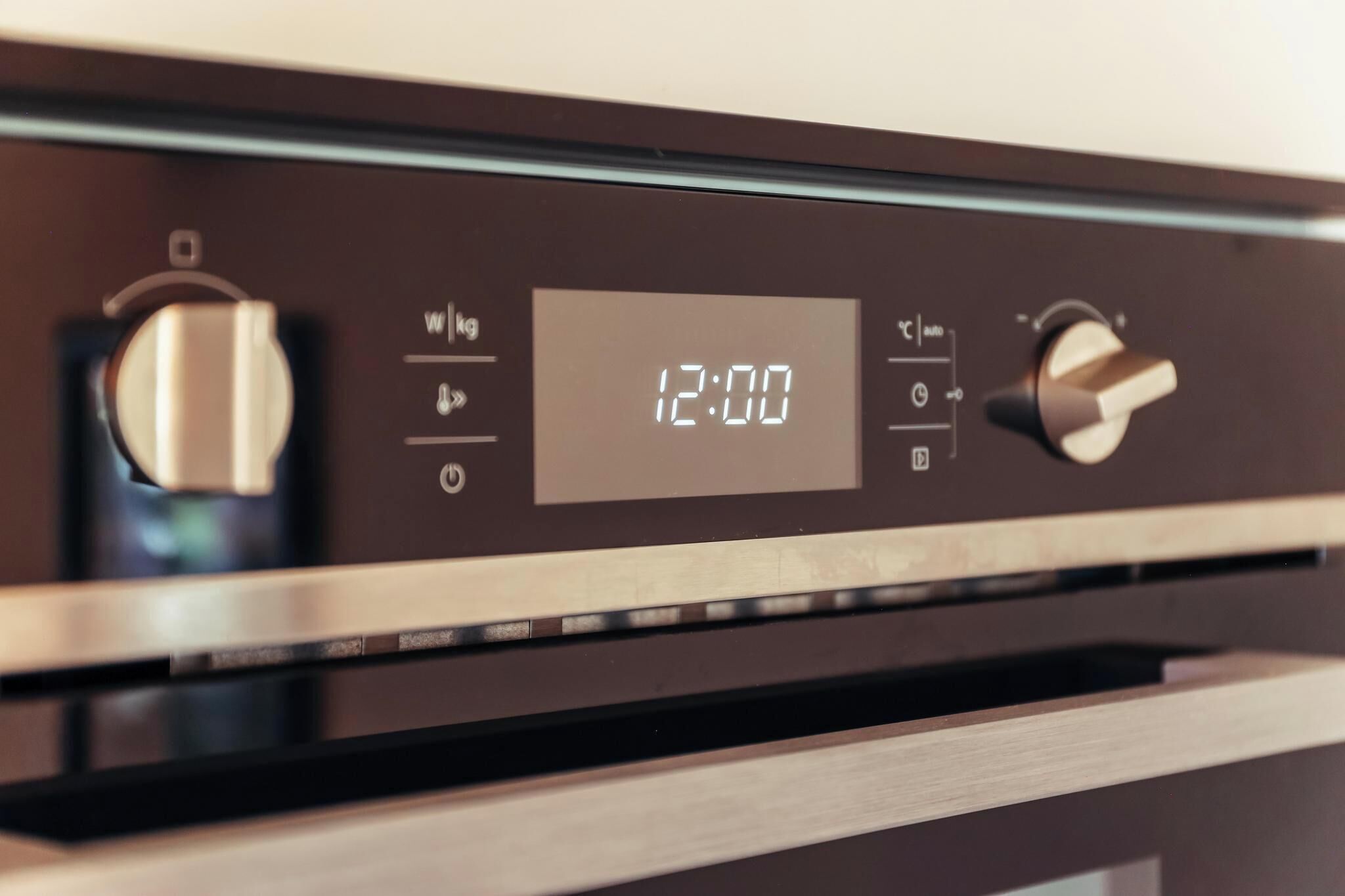 A digital display on a kitchen appliance with a timer set to 12:00.