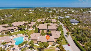 A resort with multiple buildings, a swimming pool, and a road.