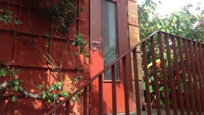 Una puerta roja con picaporte de metal, marco de madera y un ventanal pequeño.