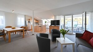 A modern living room with a dining area, a kitchen, and a balcony with outdoor furniture. - 6 pers. Apartment 13 Villa Celia Sellin - Villa Celia Sellin (Sellin)