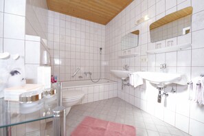 Bañera con ducha, secador de pelo, toallas, papel higiénico
