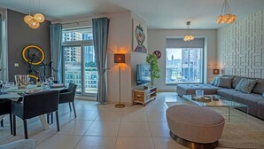 Uma sala de estar moderna com área de jantar, janelas amplas e vista para a cidade.