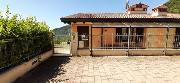 A building with a tiled roof, a fenced entrance, and a sign indicating a restaurant.
