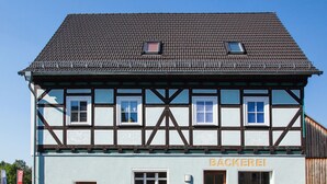 Un bâtiment traditionnel à colombages, dont la façade porte une enseigne indiquant « BACKEREI ».