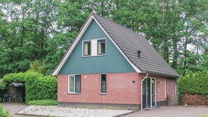 A small, single-story house with a steep gable roof, a brick exterior, and a front door. - Amazing home in Winterswijk with WiFi (Winterswijk)