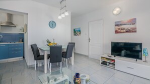 A modern living room with a dining area, a TV, and a kitchen. - 1 bedroom awesome apartment in Stara Baska (Stara Baska)