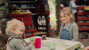 A child playing with a toy at a table with a patterned tablecloth. - Groat Fleet **** - Groat Fleet (Neuenkirchen)