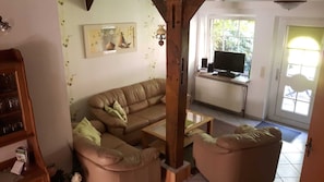 Un salon avec un canapé, une table basse et un téléviseur.