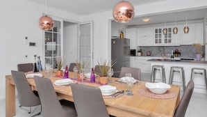 A modern kitchen with white cabinets, a central island, and pendant lighting. - Top Features! Holiday house with heated pool with sea view, for 10 people (Makarska)