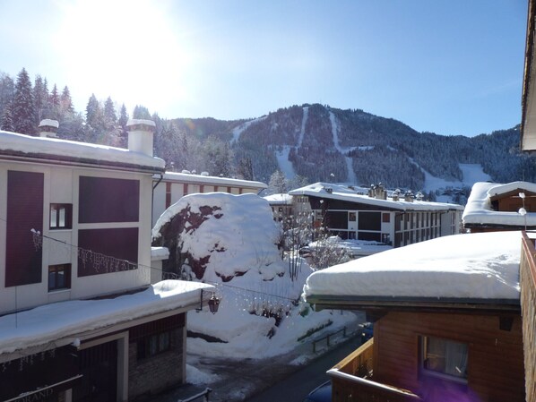 A snow-covered mountain with buildings in the foreground. - 3BR Apartment in Village Center, Near Ski Lifts, Wi-Fi, Parking (La Clusaz)