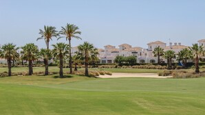 Un campo da golf con un club house sullo sfondo.