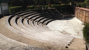A semi-circular outdoor amphitheater with tiered seating made of wood and concrete.