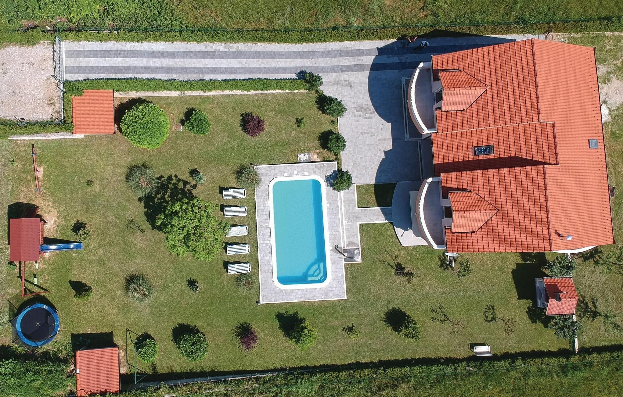 Il s’agit d’une propriété résidentielle dotée d’une piscine, d’un court de tennis et d’un patio couvert.