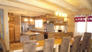 A wooden interior with a kitchen, dining area, and a large window with curtains. - Upscale chalet not far from the ski slopes  (Châtel)