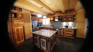 A kitchen with wooden cabinets, a central island, and a built-in oven. - Upscale chalet not far from the ski slopes  (Châtel)