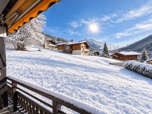 A snow-covered mountain village with wooden buildings and a clear sky.