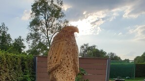 A wooden sculpture of an eagle perched on a tree stump, surrounded by pebbles and a small circular stone with a compass design. - quiet, attractive apartment with 2 bedrooms (Meiningen OT Walldorf)