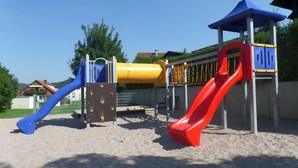 A playground with a blue slide, a yellow tube slide, and a red slide. - quiet, attractive apartment with 2 bedrooms (Meiningen OT Walldorf)