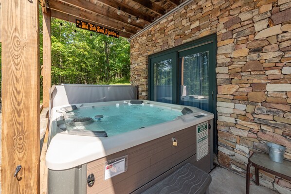 Relax in a secluded hot tub under a shaded pergola surrounded by lush greenery.