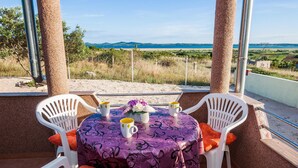 Une table recouverte d’une nappe violette, entourée de chaises blanches et agrémentée de tasses jaunes, offrant une vue sur un paysage pittoresque.