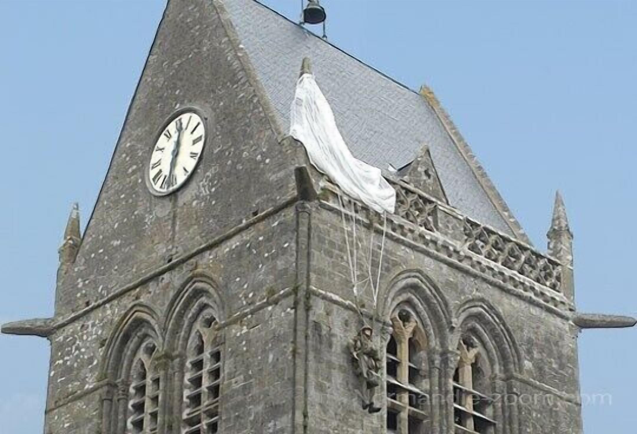 Een historisch gebouw met een klok, puntige dak en boogvensters.