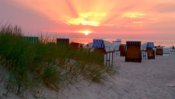 Beach huts with a sunset in the background. - Apartment stylish + cozy, in 3 minutes at the sea or in the center :) with parking space (Rostock)