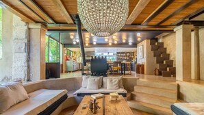 Un salon chaleureux avec une table basse en bois, un canapé et un escalier menant à une autre pièce.