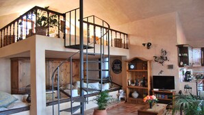 A spacious living area with a spiral staircase, wooden furniture, and various decorative items. - Light-flooded country house with WiFi connection * Last minute offer * (La Orotava)