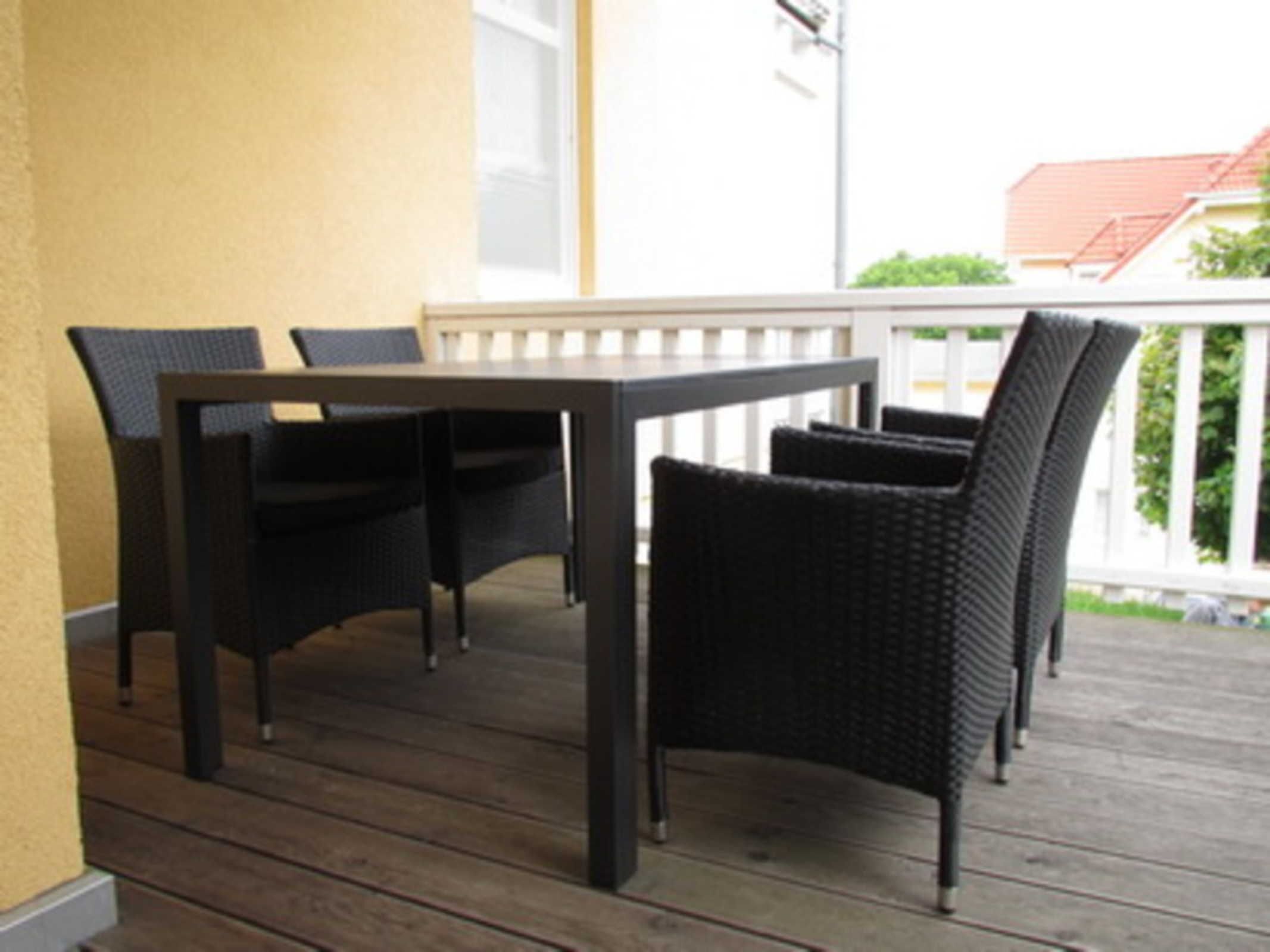 A wooden deck with a table and four chairs.