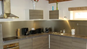 A modern kitchen with a built-in oven, a coffee maker, and a sink.
