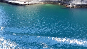 A coastal cliff with a clear blue sea in the foreground and a fortified structure on top. - Guest house 1 air-conditioned bedroom with private bathroom and bedroom wc (Porto-Vecchio)