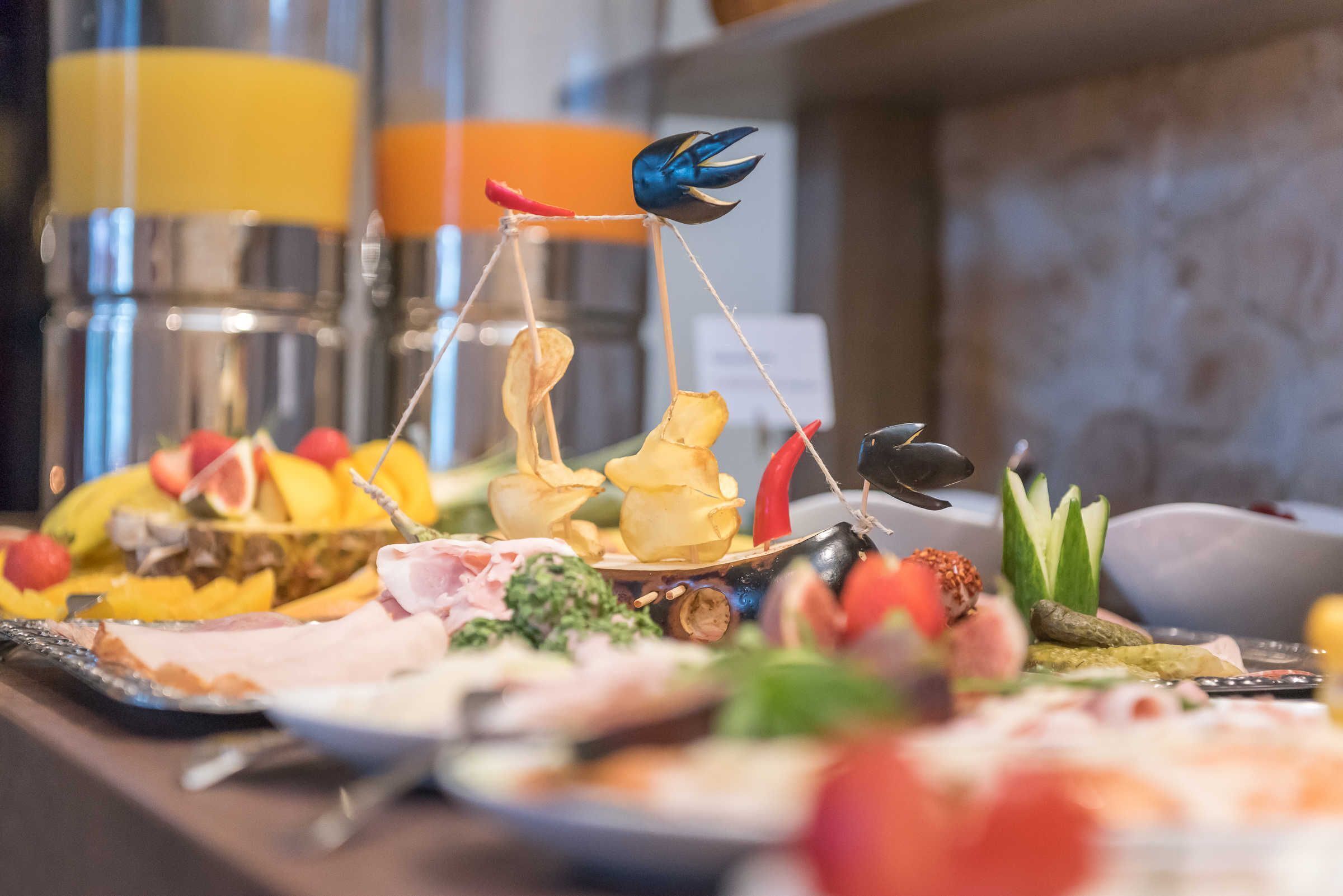 A buffet with various food items including fruits, vegetables, and meats.