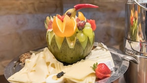A fruit arrangement on a plate with cheese and a small bowl of caviar. - Comfort room - Aparthotel Waldfrieden (Sellin)