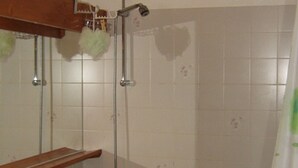 A bathroom with a sink, mirror, and shower.