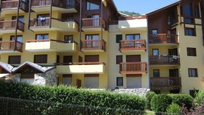 A multi-story hotel with balconies, a stone facade, and a clear sky.
