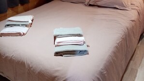 Une pièce aménagée comme un chalet en bois, avec un lit, des oreillers et des serviettes pliées.