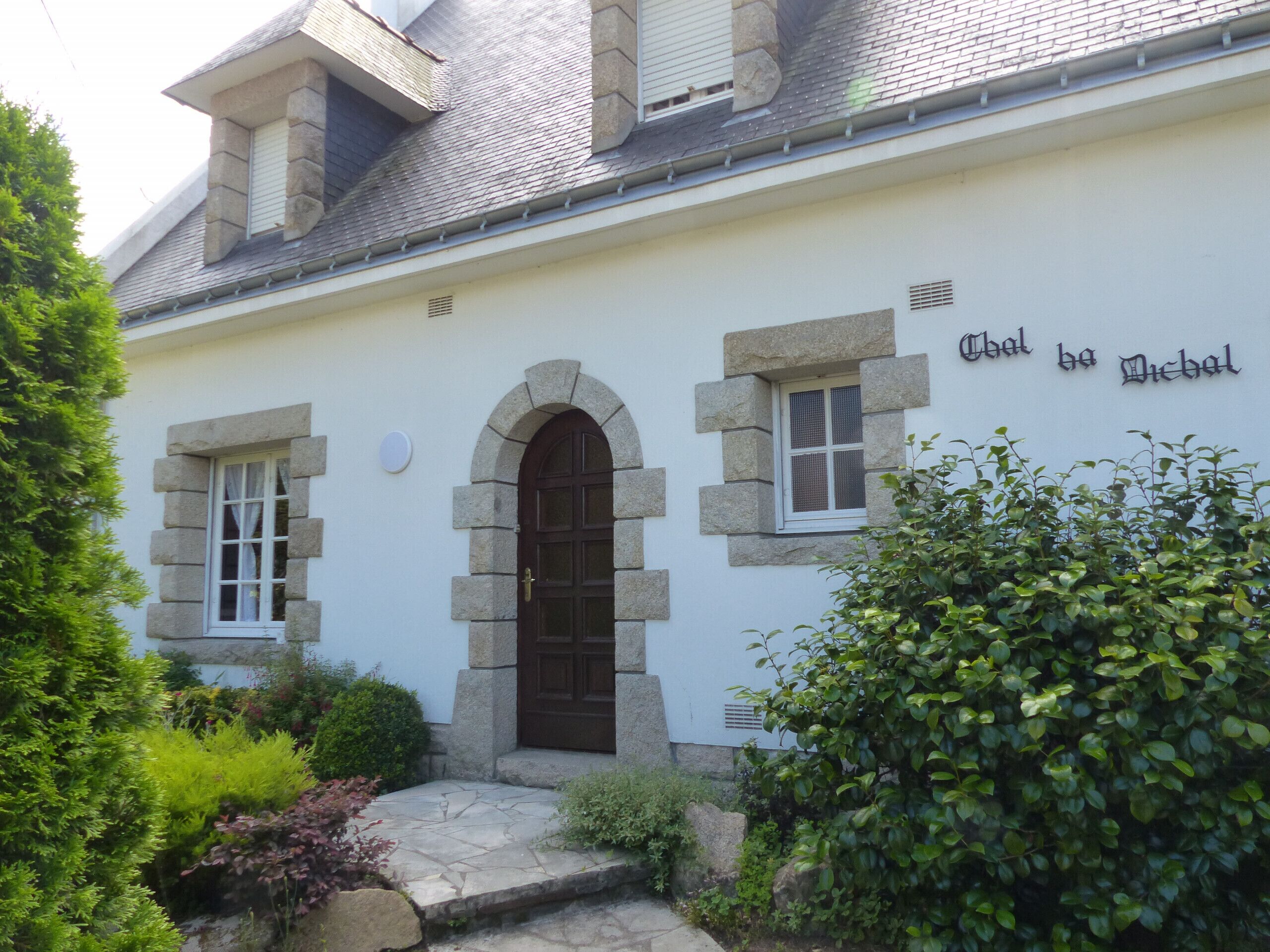 Un bâtiment à la façade en pierre, doté d’une entrée centrale en arc de cercle et d’une enseigne indiquant « Chalet de Diebel ».