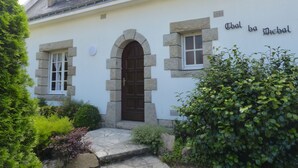 Un edificio con fachada de piedra, una entrada central en arco y un letrero que dice 