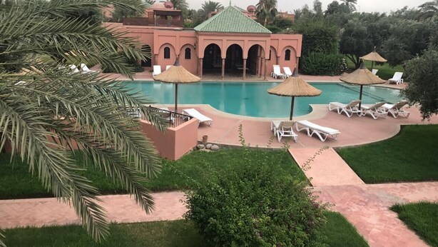 A resort with a large pool, palm trees, and lounge chairs. - Villa with pool in Marrakech (Marrakech)