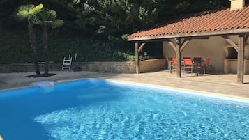 Een verwarmd zwembad en ligstoelen