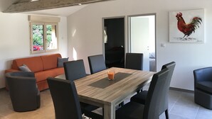 A dining area with a wooden table, black chairs, and a glass of orange juice. - Bed and Breakfast Sarlat Canada (Sarlat-la-Canéda)