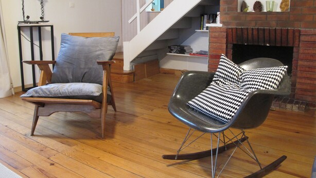 A living room with a wooden floor, a rocking chair, a chair with a cushion, a staircase, and a fireplace. - House Ville d'Hiver, Arcachon center - 2 bedrooms - Parquet (Arcachon)